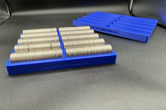 Blue coin storage trays with rolls of coins on a gray surface